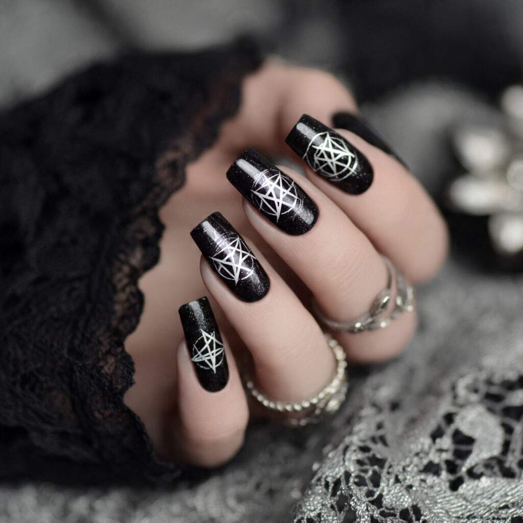 black nails adorned with white pentagram symbols